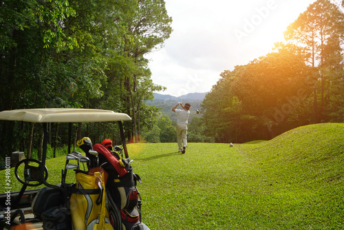 Blurred golfer playing golf beside the golfcar in beautiful golf course in the evening golf course with sunshine in thailand photo