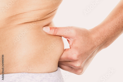 Love handle woman pinching fat on hips around waist - weight loss diet concept.