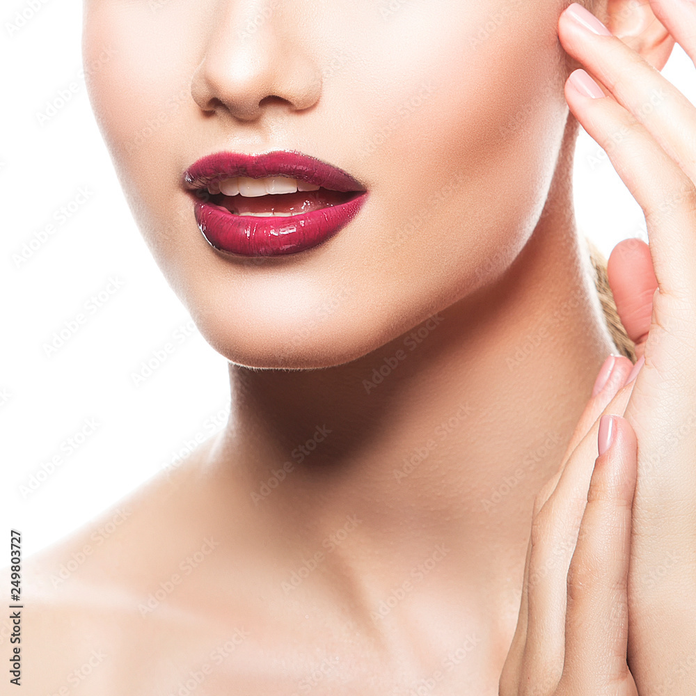 Red lips, part of face and habd of fashion model girl with perfect skin, bright make-up. White background. Facial treatment concept