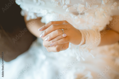 Beautiful bride with white wedding dress hold her wedding ring in smooth feeling.