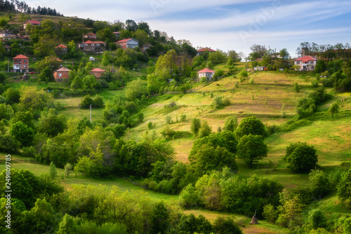 Spring is coming... Amazing spring view with a little village in Rhodopi Mountains, Bulgaria. Magnificent landscape, green fields, small houses