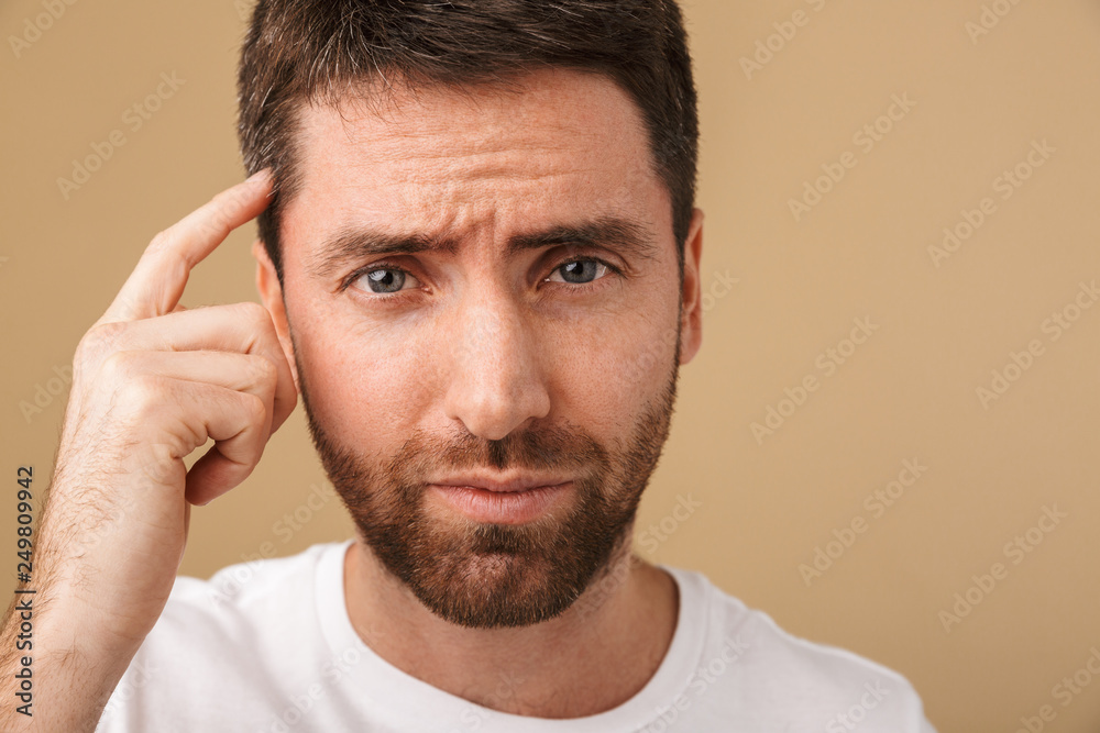 Obraz premium Portrait of a pensive young man standing isolated