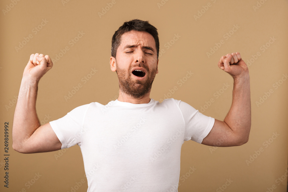Portrait of a tired young man standing isolated Portrait of a tired young man standing isolated