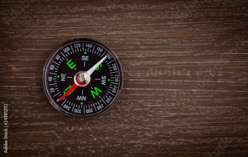 compass on wood background concept for direction, travel, guidance or assistance