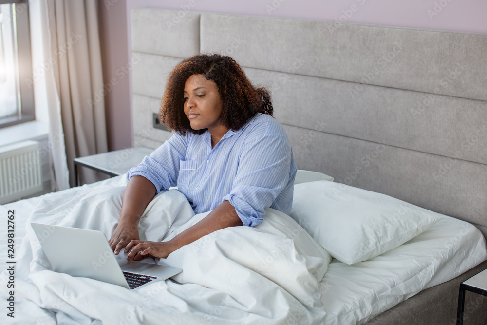 serious girl wth curly working on the computer. close up side view photo. girl looking for the Internet connection