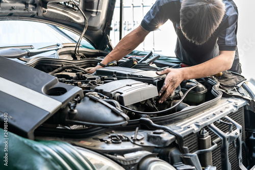 repairman or mechanic during car repair investigate cause of problem (mechanism or combustion system check) automobile gasoline or diesel engine at garage