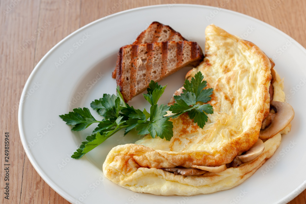 Omelet with mushrooms, decorated with herbs and toast.