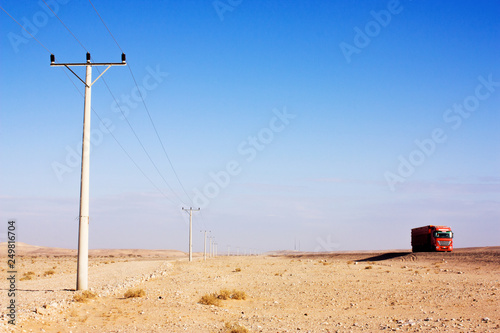 Wallpaper Mural Electric power poles in desert of Jordan. High voltage powerlines. Early morning in wilderness after sunrise. Red truck on road. Torontodigital.ca