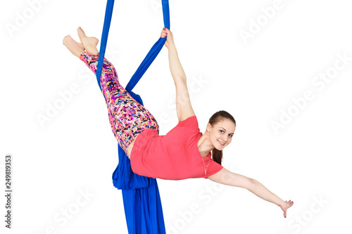 Young girl gymnast hanging on the canvases. Aerial gymnastics on a white background.