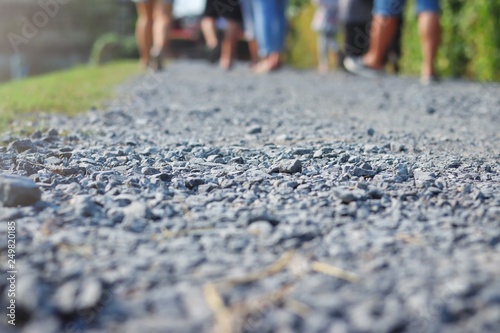 gray granite gravel walking way with many people is walking