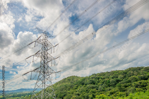 High voltage transmission line and poles as background Mountain and blue sky . An idea of electricity transmission and distribution. 