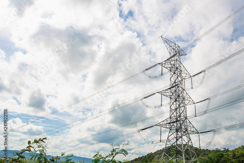 High voltage transmission line and poles as background Mountain and blue sky . An idea of electricity transmission and distribution. 
