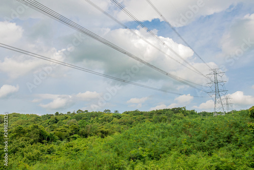 High voltage transmission line and poles as background Mountain and blue sky . An idea of electricity transmission and distribution. 