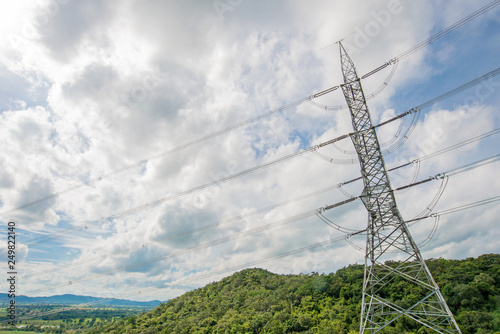 High voltage transmission line and poles as background Mountain and blue sky . An idea of electricity transmission and distribution. 