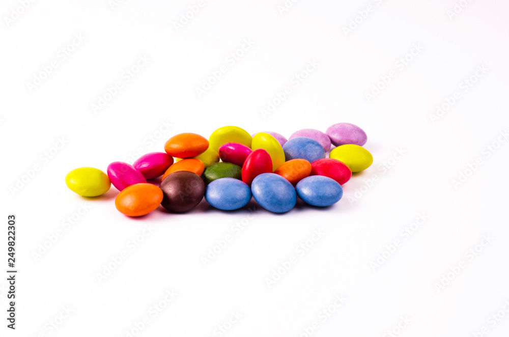 Chocolates with a multi-colored coating on a white background Chocolates with a multi-colored coating on a white background