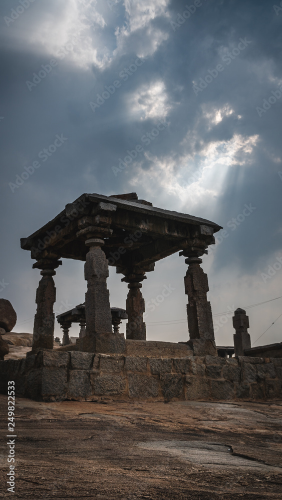 little stone temple with dramatic mystic cloudy sky in hampi india karnakata