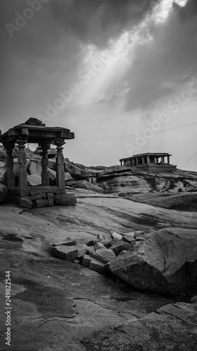 little stone temple with dramatic mystic sky in hampi india karnakata black and white