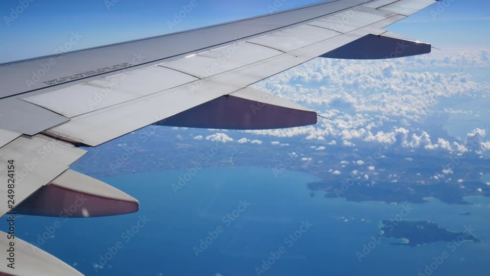 View from the window of the plane wing of an airplane flying above the clouds View from the window of the plane wing of an airplane flying above the clouds