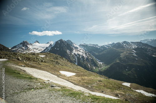 Panoramic view on the Furka Pass in Switzerland. Sunny weather and on the mountain peaks a rest of snow.