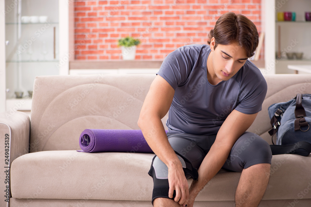 Young handsome man doing sport exercises at home 