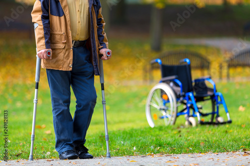 older man practicing walking on crutches