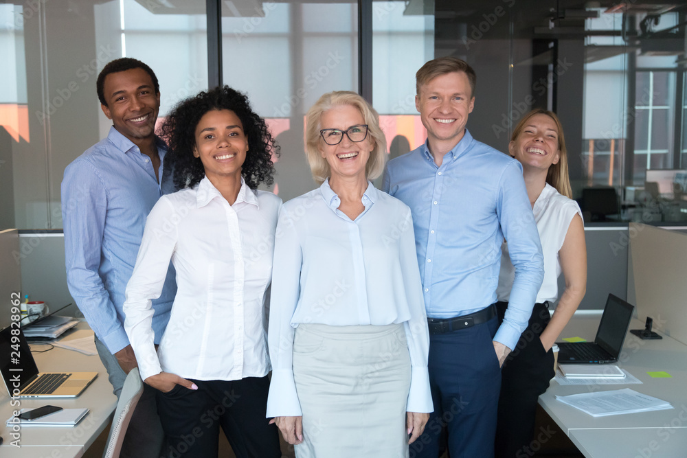 Diverse colleagues led by company chief posing for camera Diverse colleagues led by company chief posing for camera