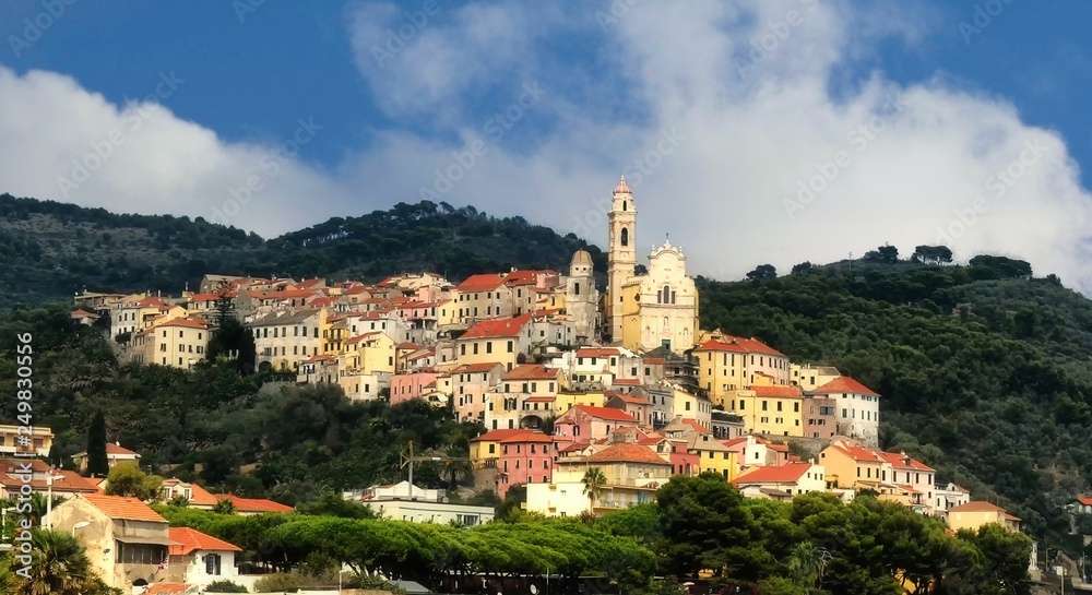 The old town of Cervo, Liguria, Italy, with the beautiful baroque church arising from the houses. Clear blue sky.