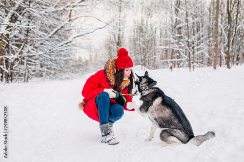 Woman caresses the Husky dog in winter forest © Elena Kratovich