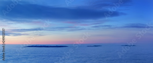 Winter High Tatras mountain range panorama with many peaks and clear sky from Slavkovsky peak. Sunny day on top of snowy mountains in winter in Slovakia. Sunset from the mountain summit.