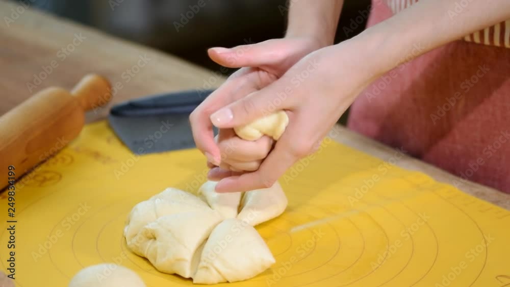 Making buns. Dough on the table. Knead the dough. Hands arranging bread for oven in a bakery. At the bakery, preparing dough to be made buns, bread factory. Making buns. Dough on the table. Knead the dough. Hands arranging bread for oven in a bakery. At the bakery, preparing dough to be made buns, bread factory.