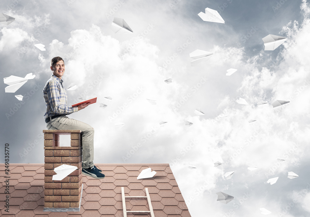 Handsome student guy reading book and paper planes flying in air Handsome student guy reading book and paper planes flying in air