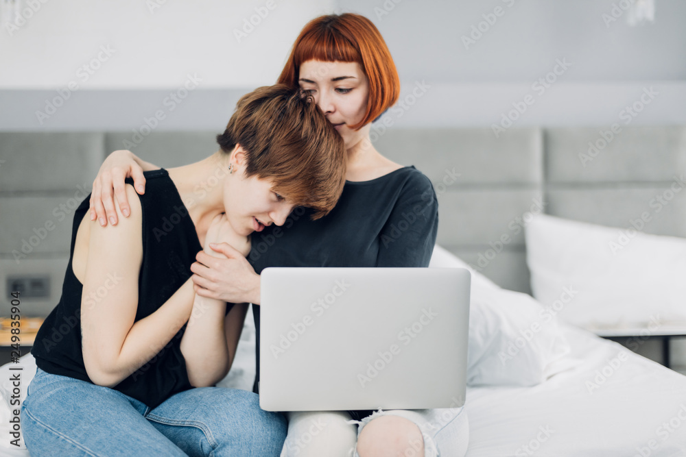Unhappy women sitting at the laptop. problem concept. ginger girl supports her friend as she is an a difficul situation. advise, help. close up photo