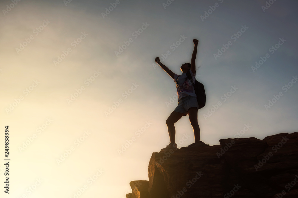 woman backpacker victory pose at mountain summit
