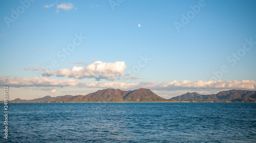 Beautiful nature scene seen on the island of Okunoshima, also known as the "Bunny Island", which is a small island located in the Inland Sea of Japan, with a waxing gibbous moon in the sky. © MyPixelDiaries