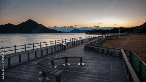 Beautiful sunset scene seen on the island of Okunoshima, also known as the "Bunny Island", which is a small island located in the Inland Sea of Japan, with boardwalks and dramatic clouds in the sky.