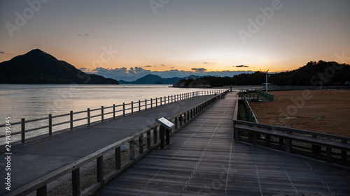 Beautiful sunset scene seen on the island of Okunoshima  also known as the  Bunny Island   which is a small island located in the Inland Sea of Japan  with boardwalks and dramatic clouds in the sky.