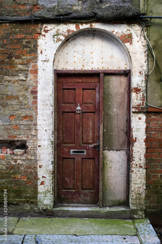 Arched doorway that looks shabby and in need of attention © Wise Dog Studios