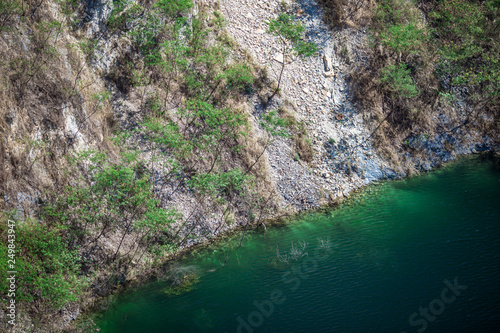 Background of reservoirs or lakes that are in tourist attractions, natural viewpoints (mountains, grass, trees, sky), natural view, intimate, surrounding atmosphere, refreshing and resting on the way 