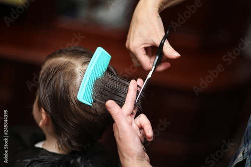 A little boy is trimmed in the hairdresser's bright emotions on face