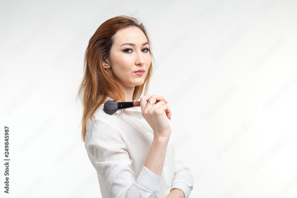 Beauty makeup artist. Close Up korean beautiful young woman pretty smiling holding make-up brushes on white background. Beauty makeup artist. Close Up korean beautiful young woman pretty smiling holding make-up brushes on white background.