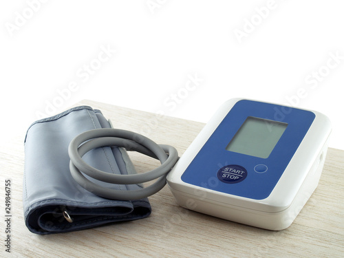 portable electronic blood pressure monitor on desk corner isolated on white