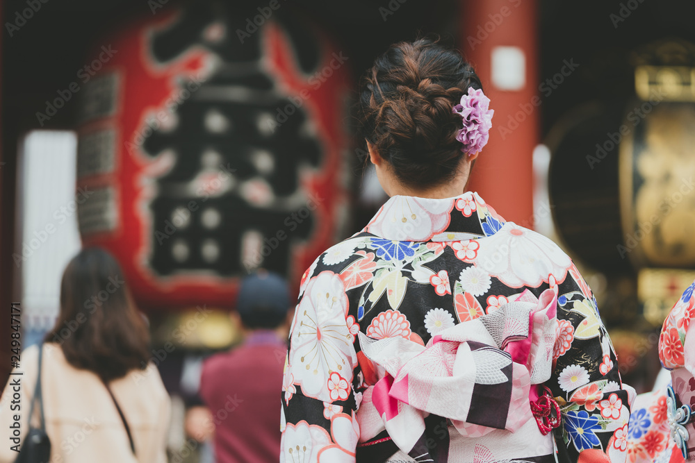 Young girl wearing Japanese kimono standing in front of Sensoji Temple in Tokyo, Japan. Kimono is a Japanese traditional garment. The word Young girl wearing Japanese kimono standing in front of Sensoji Temple in Tokyo, Japan. Kimono is a Japanese traditional garment. The word