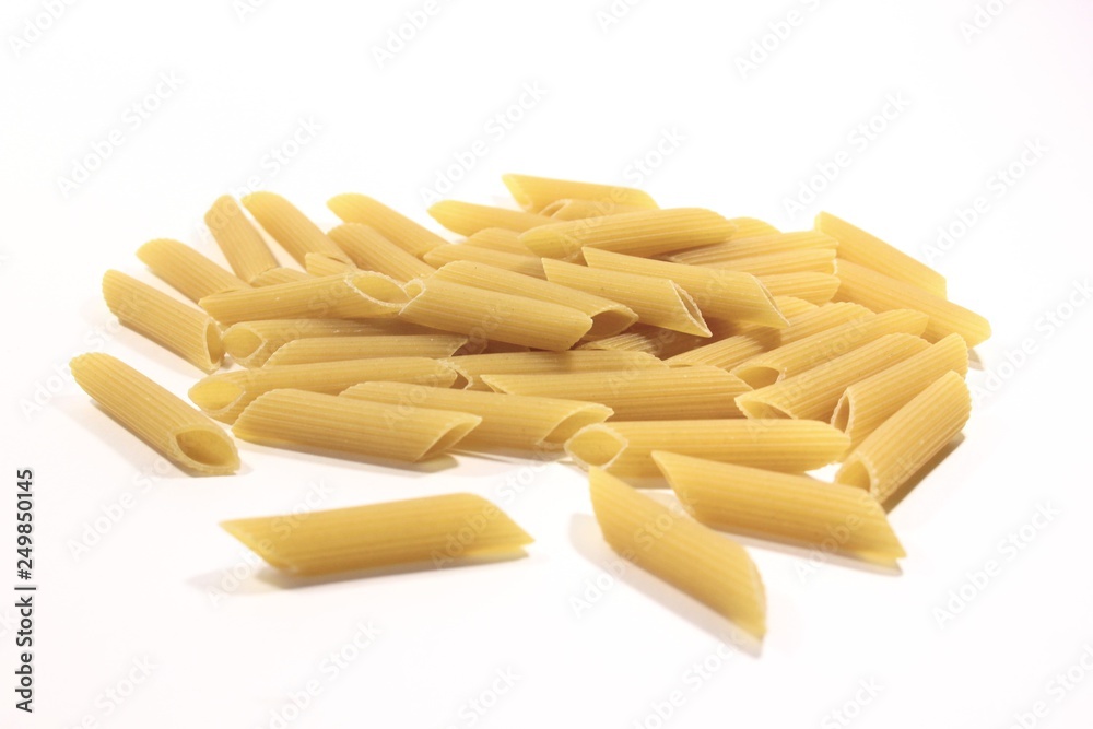 A small pile of durum wheat pasta against a white background. Tasty and healthy food for adults and children. A small pile of durum wheat pasta against a white background. Tasty and healthy food for adults and children.