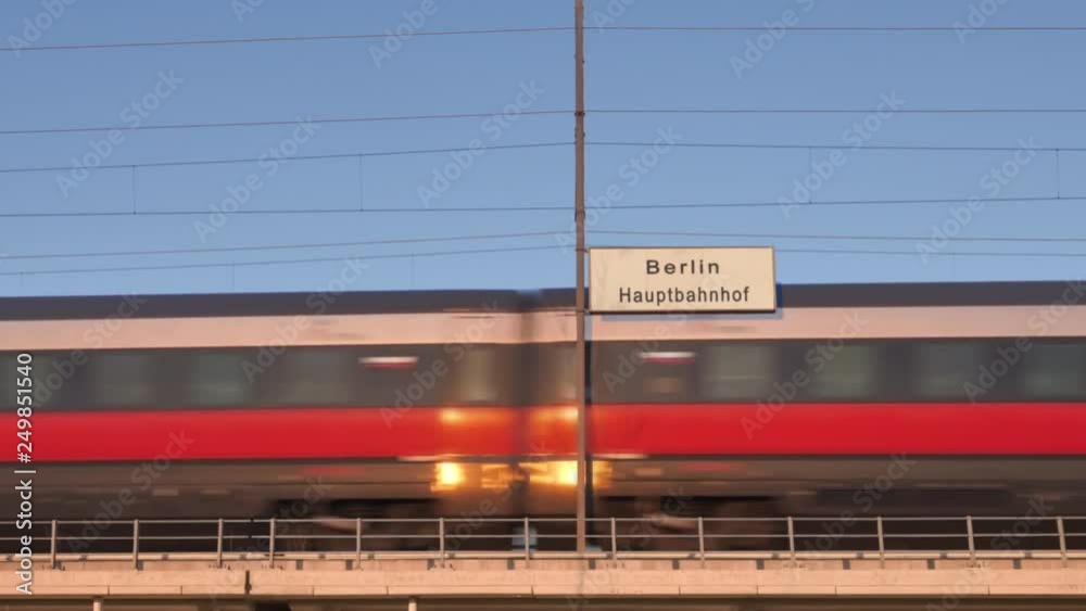 berlin railway billboard train passing behind train station signboard