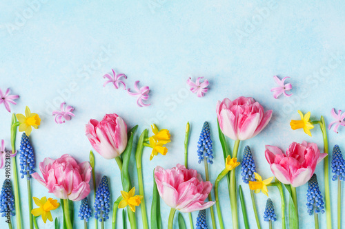 Creative composition of beautiful spring flowers on pastel table top view. Greeting card for International Women Day. Flat lay.