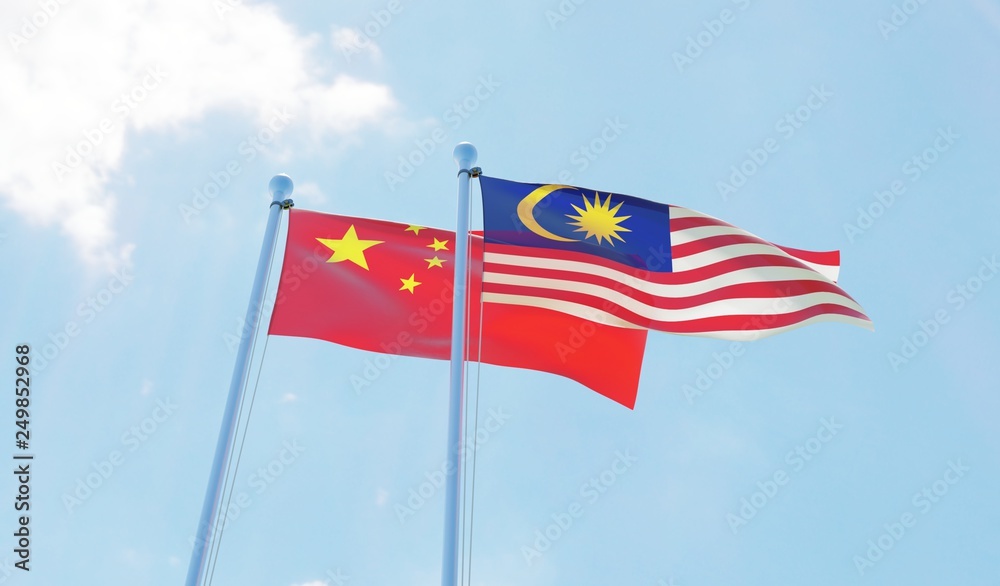 Malaysia and China, two flags waving against blue sky. 3d image