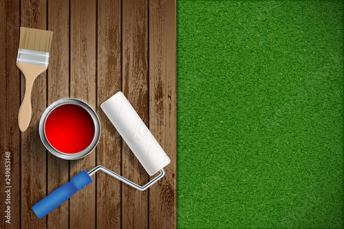 Paint roller, paint brush on wood and lawn background.