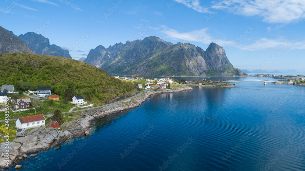 Beautiful summer aerial view of Reine, Norway, Lofoten Islands, with skyline, mountains, famous fishing village with red fishing cabins, Moskenesoya, Norway