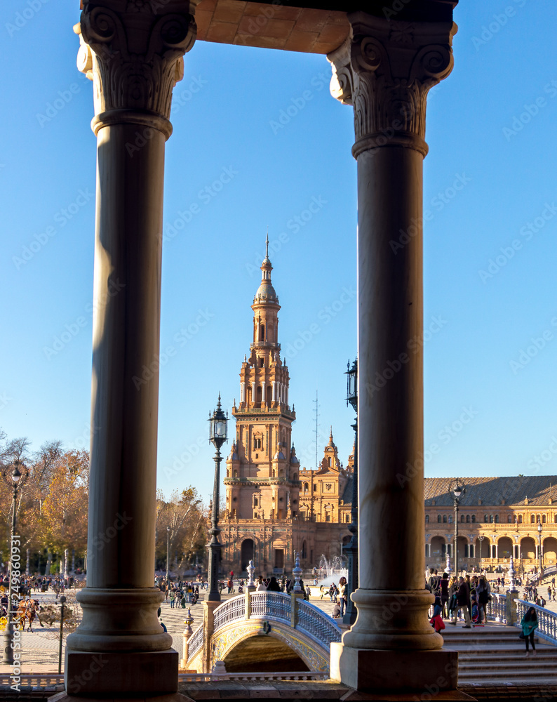 tower seen between two pillars in seville