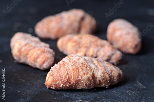 group of sugary croissants on dark blue textured background